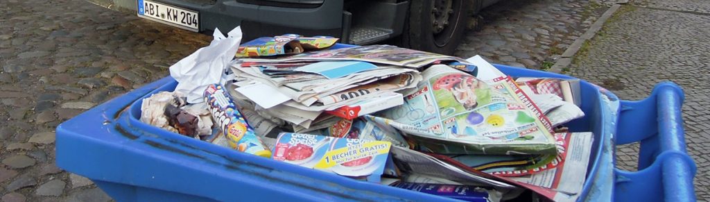 Foto: Eine volle Altpapiertonne mit zur Umleerung geöffnetem Deckel