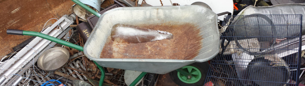 Eine Schubkarre aus Leichtmetall in einem Altmetallcontainer