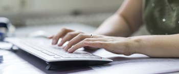 Hände bei der Arbeit auf einer Computertastatur | abfallbild.de