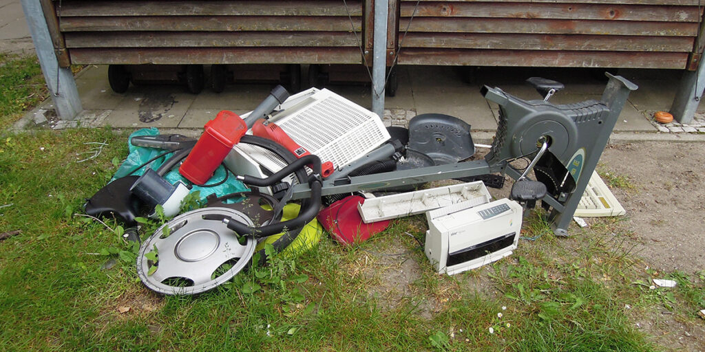 Foto | Radkappen, ein kaputter Hometrainer und anderer Abfall neben der Müllstandsfläche abgelegt