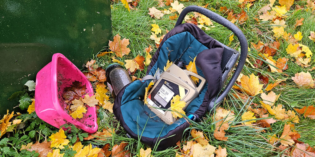 Foto | Sperrmüll , eine Plastewanne und gefährliche Flüssigkeiten, hinter einem Altkleidercontainer abgestellt